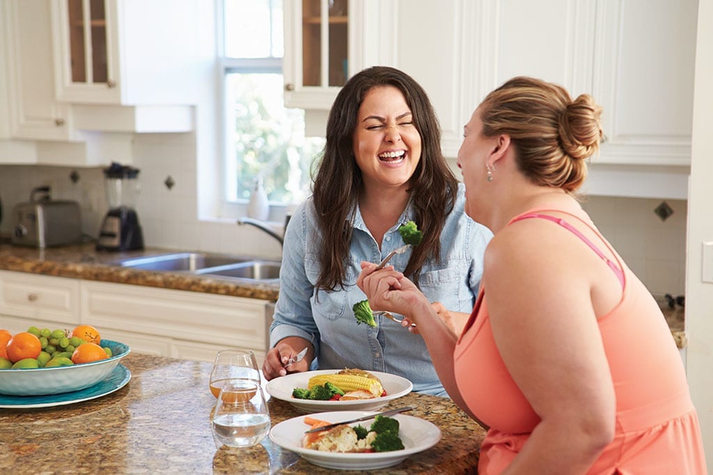 Women Eating Healthy Meal In Kitchen